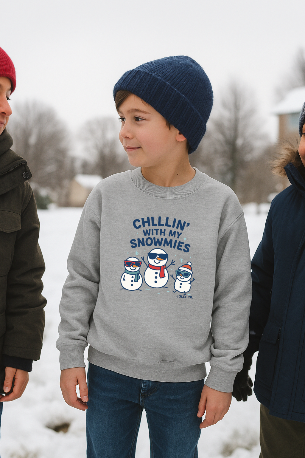 Child wearing a gray sweatshirt with snowman design and text in a snowy setting